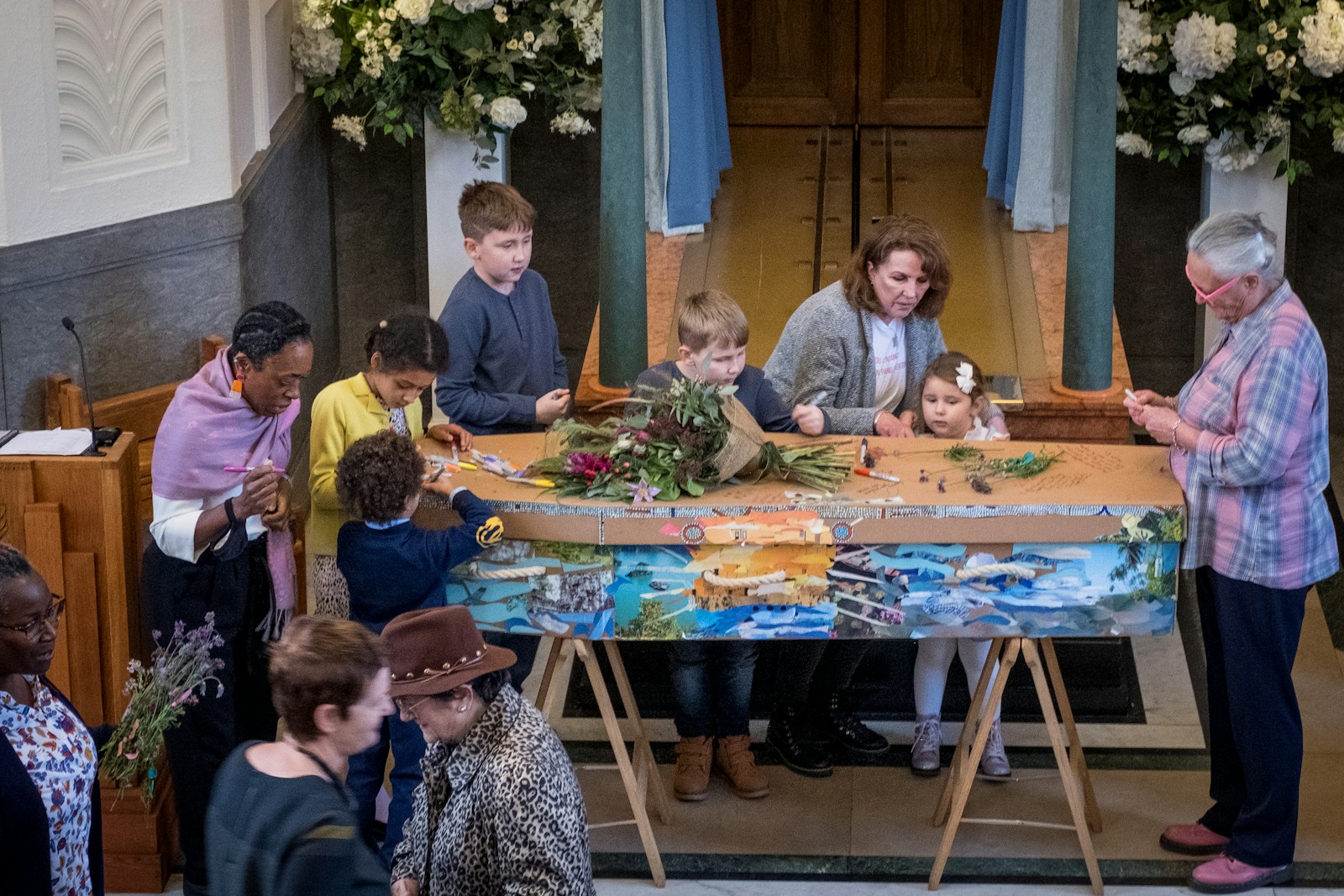 a group of people standing around a wooden table